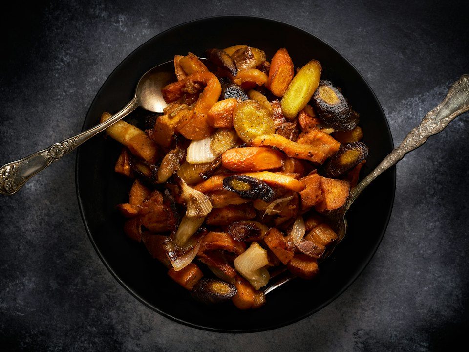 Carottes, champignons et oignons rôtis dans une poêle en fonte