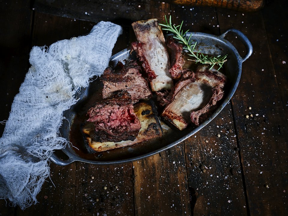 Côte de bœuf tranchée, rosée à cœur, avec du romarin