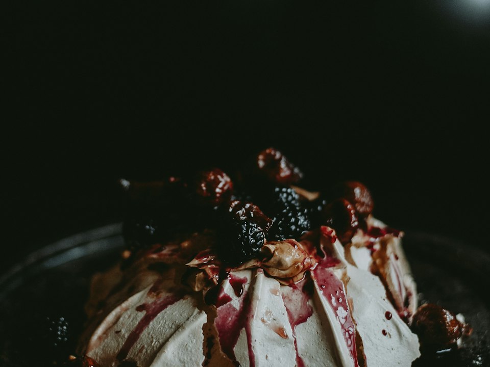 Meringue nappée de coulis, mûres et fruits noirs